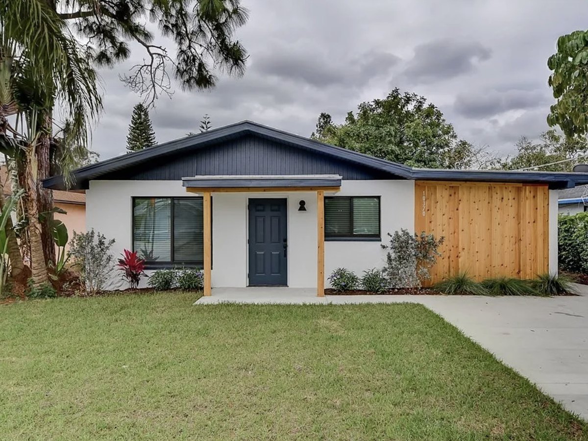 Renovated single-story ranch in Bonita Springs, Florida, with new roof, windows, covered entry and concrete driveway.