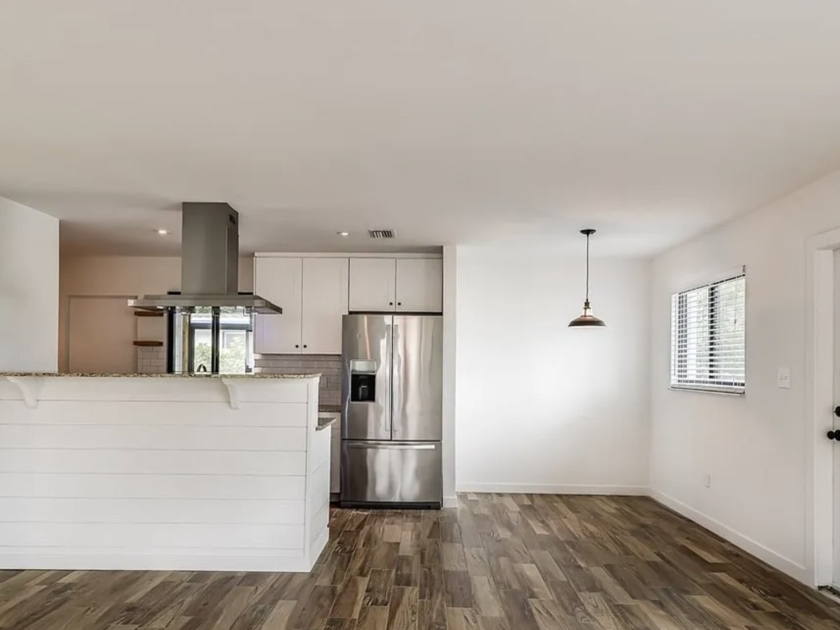 The renovated kitchen and living space seen as one room, with the peninsula standing where the dividing wall used to be.
