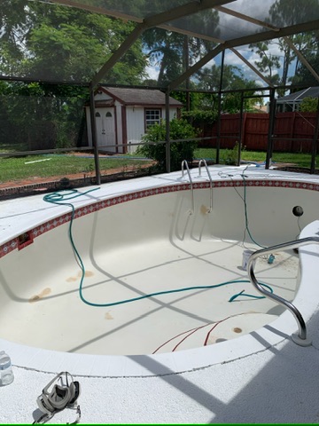 The same pool drained and cleaned, the shell bare and the fittings exposed, ready for replastering.